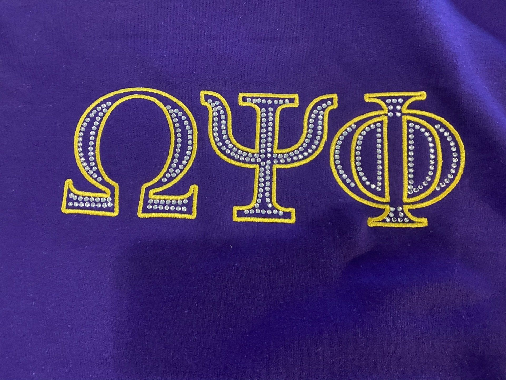 A close up of a purple shirt with the letter o on it