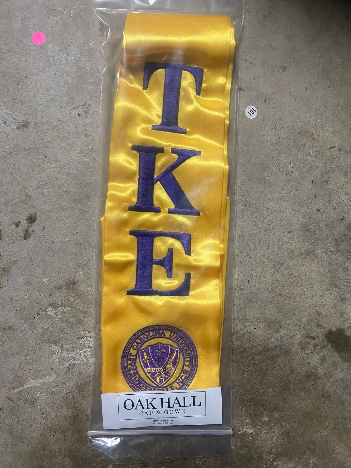 A yellow sash that says tk e on it
