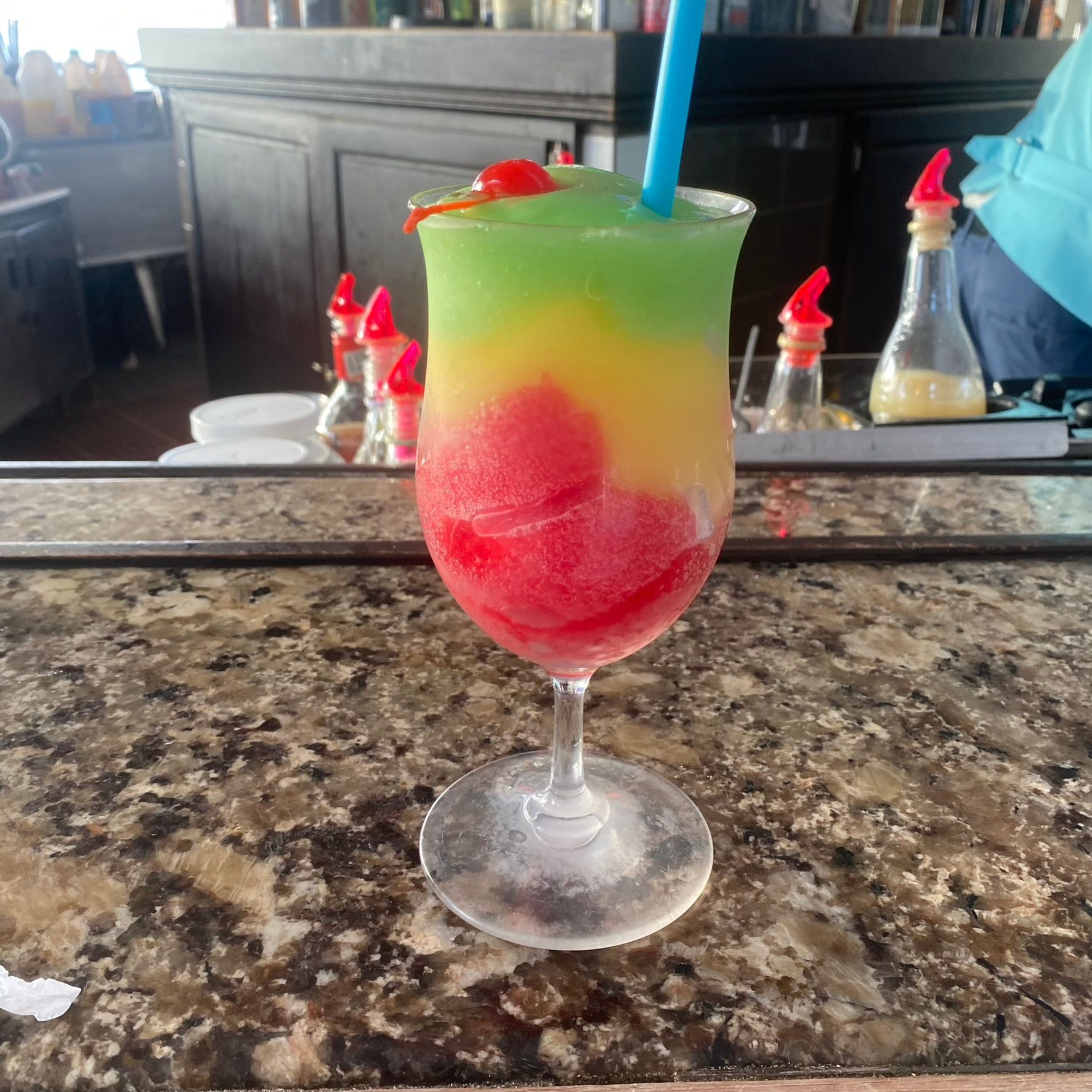 A frozen drink in a wine glass with a straw