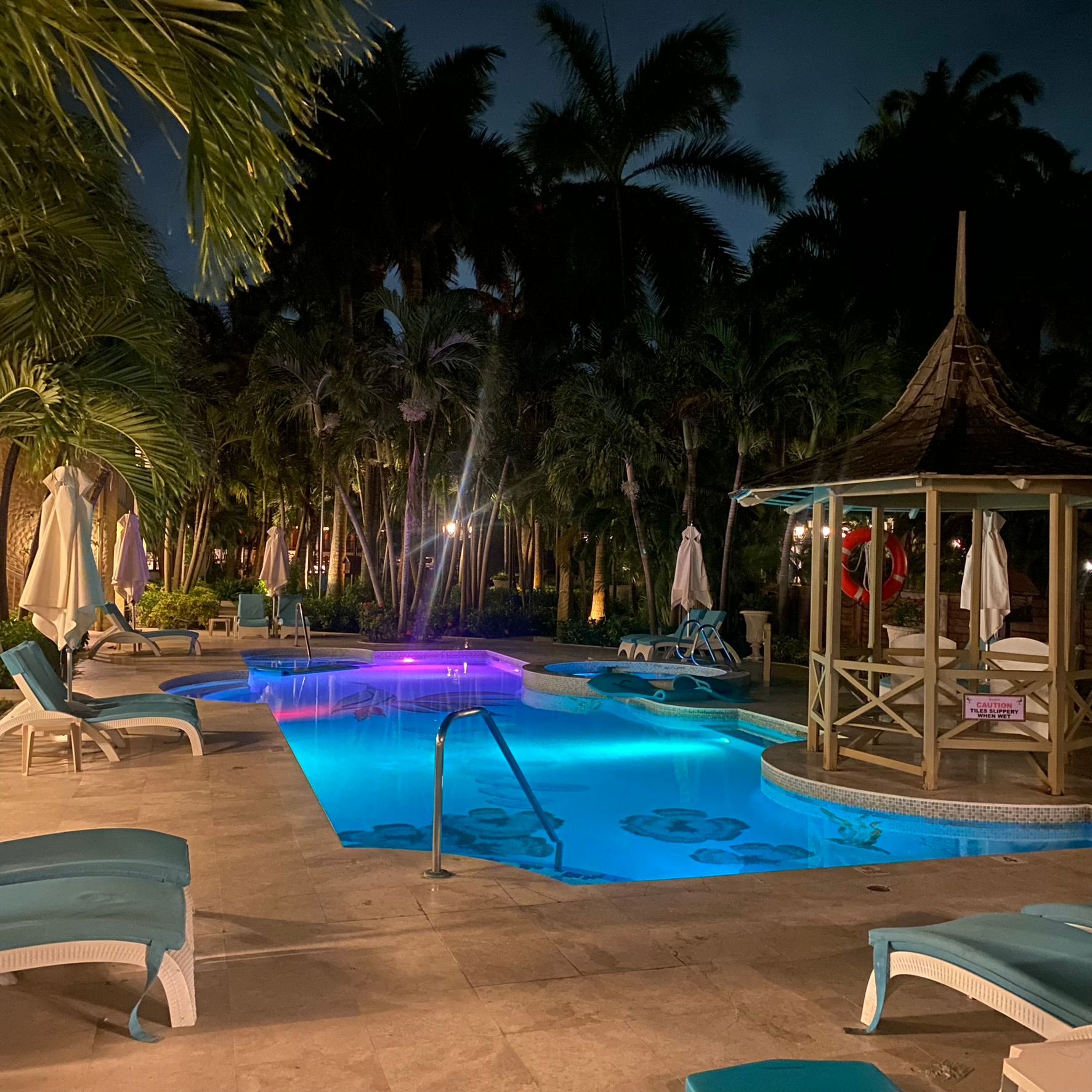 A large swimming pool is lit up at night