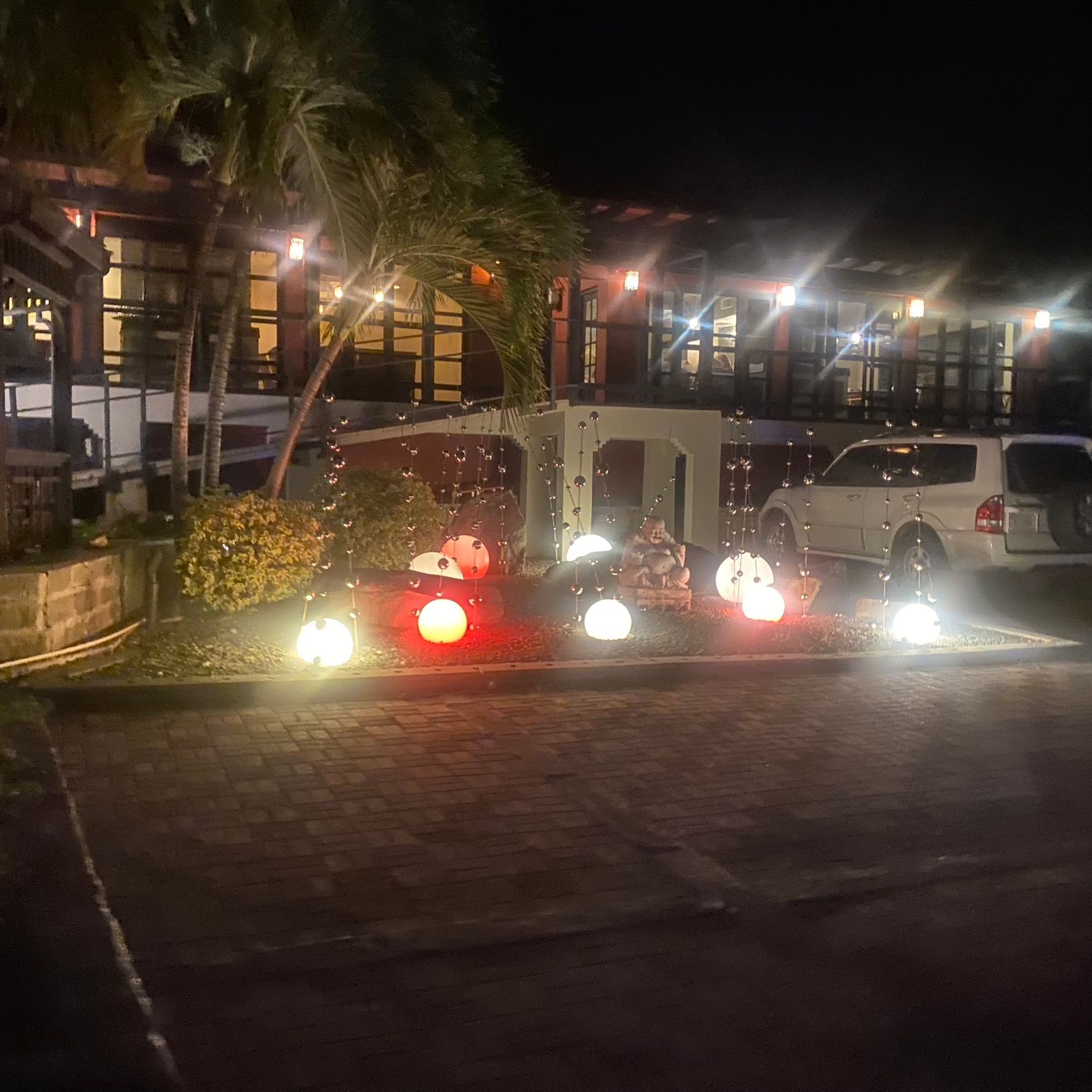 Several cars are parked in front of a building at night