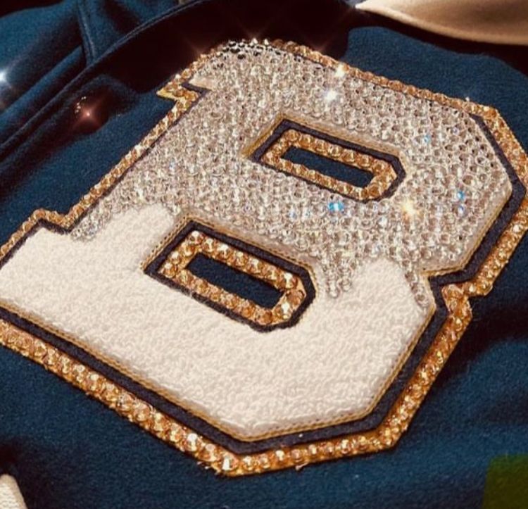 A letter b is covered in rhinestones on a blue jacket