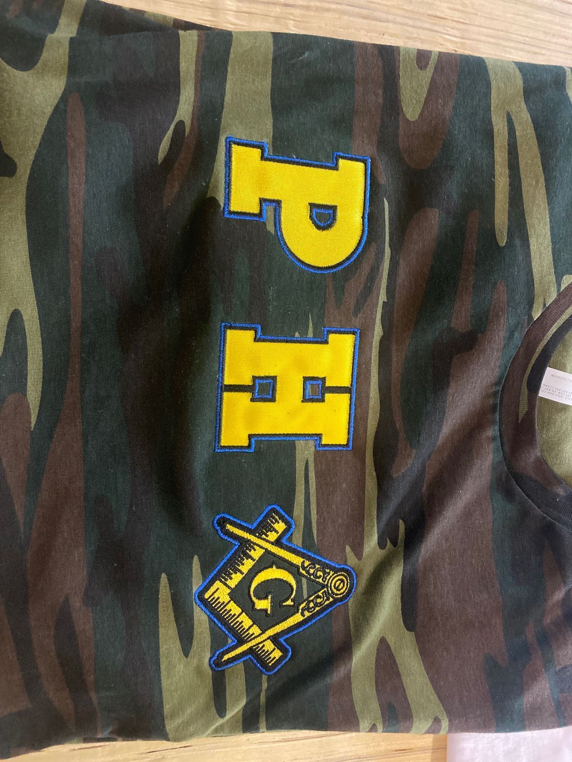 A camouflage shirt with the letter p on it
