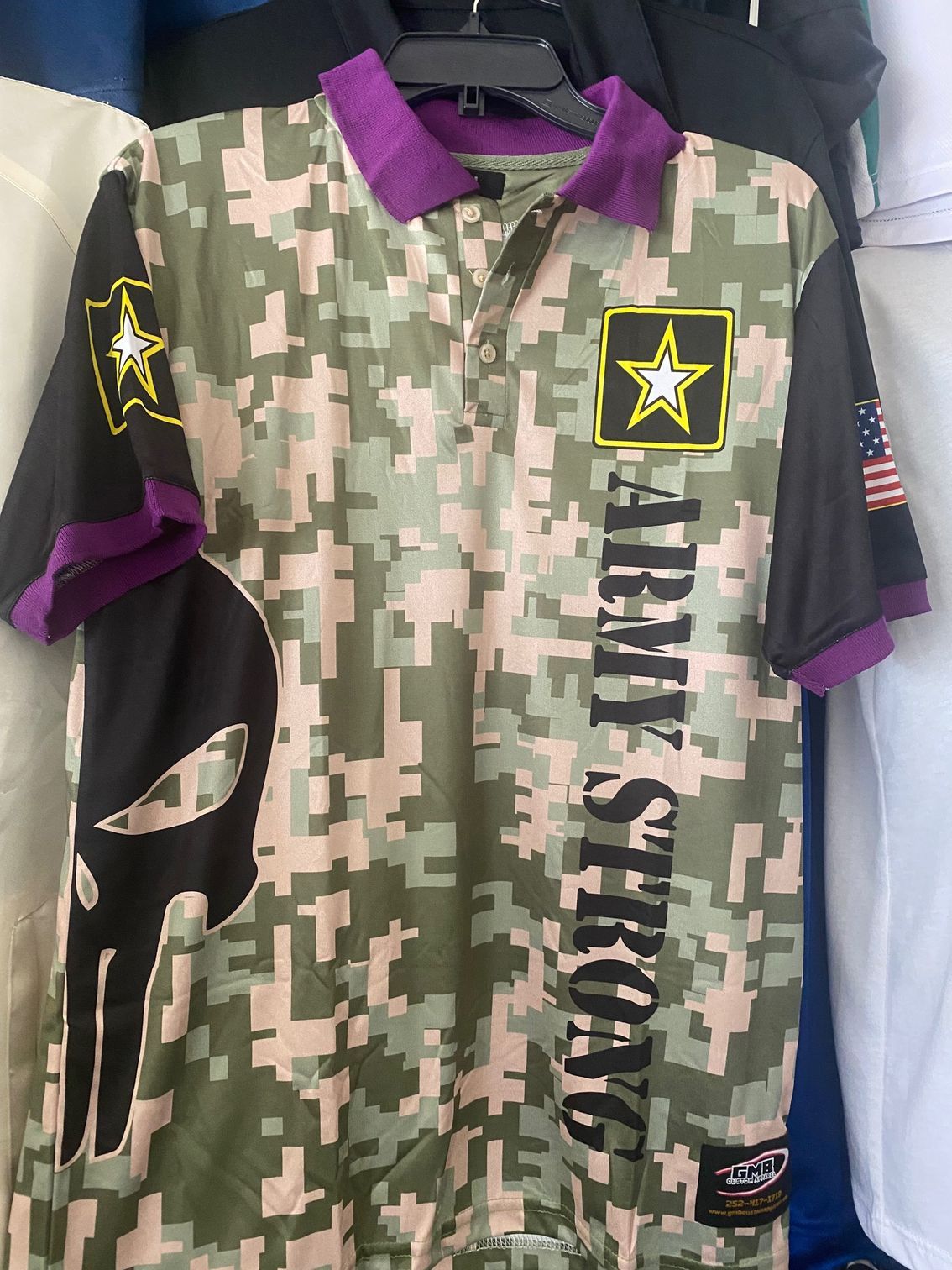 A army strong polo shirt is hanging on a hanger.
