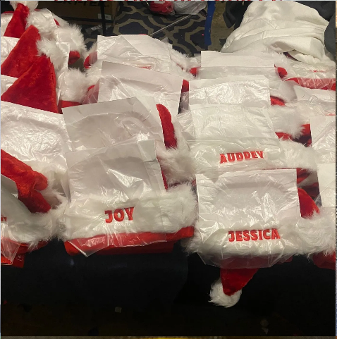 A pile of santa hats with the names joy and jessica on them