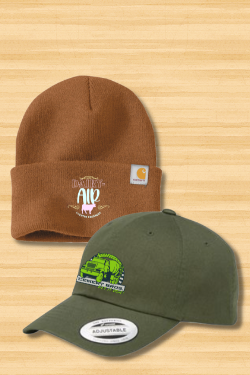A brown beanie and a green baseball cap are on a wooden table.