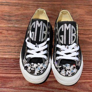 A pair of black converse shoes with monograms on them