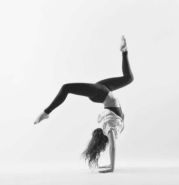 A woman is doing a handstand in a black and white photo.