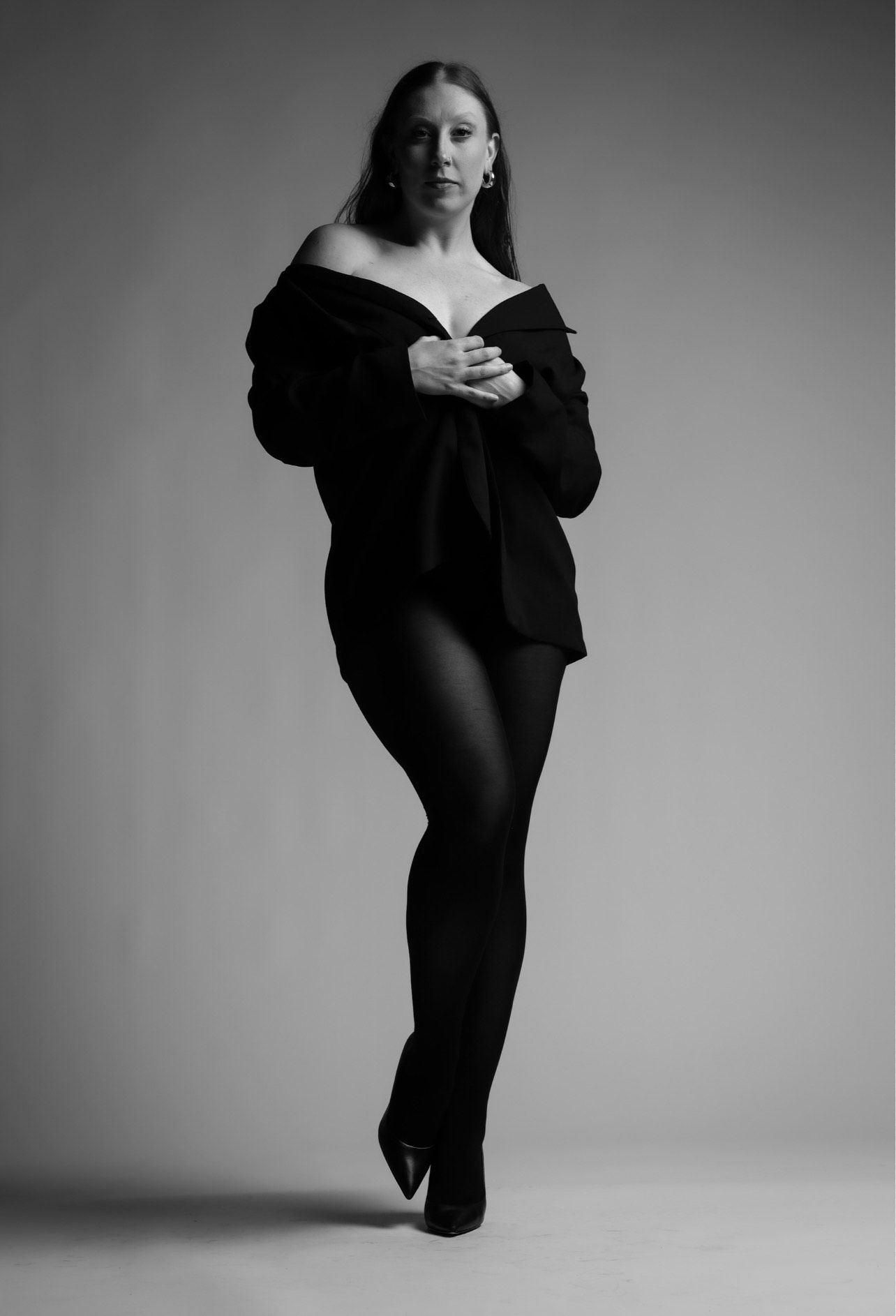 A black and white photo of a woman jumping in the air.