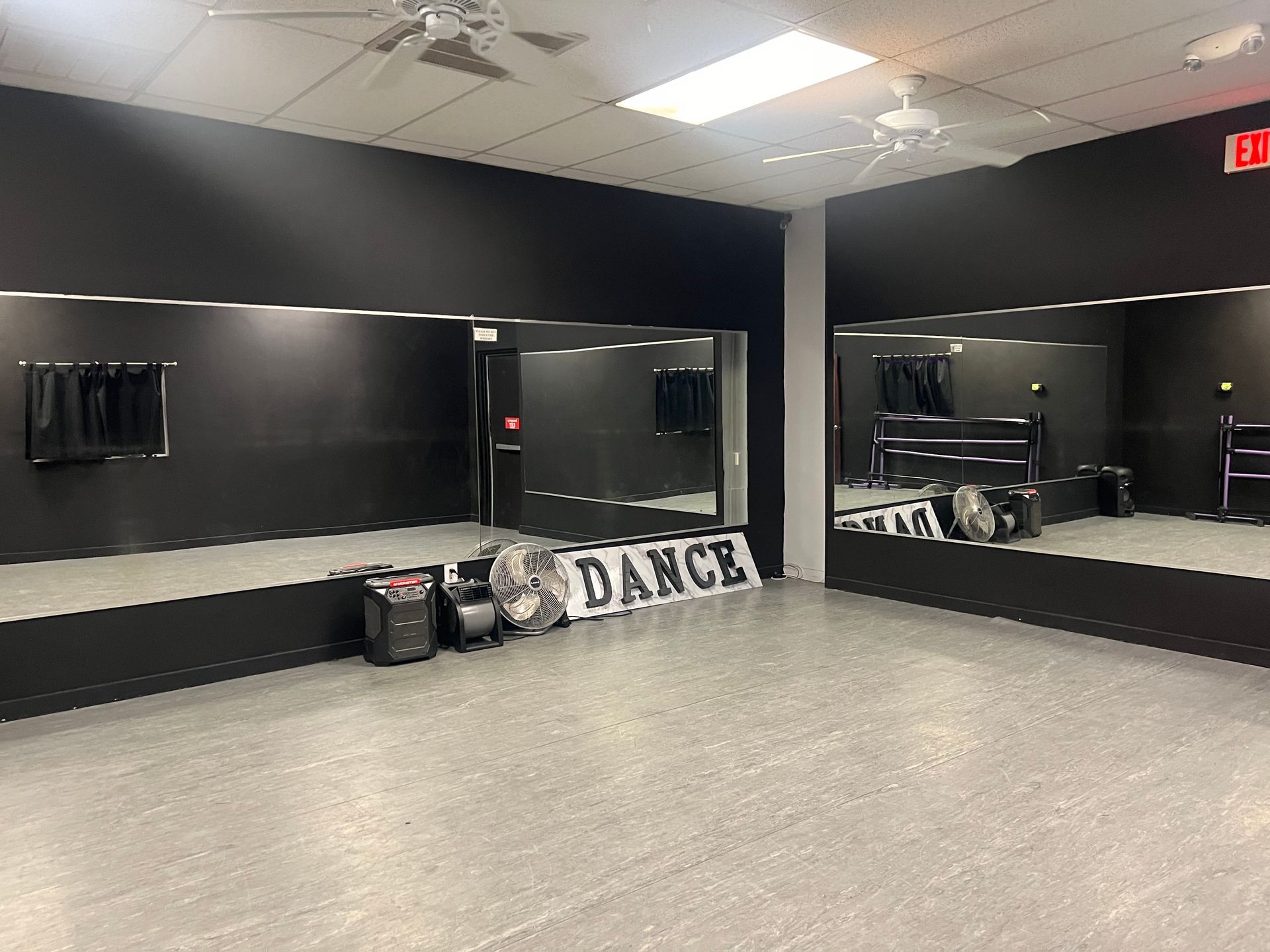 A dance studio with a lot of mirrors and a sign that says dance.