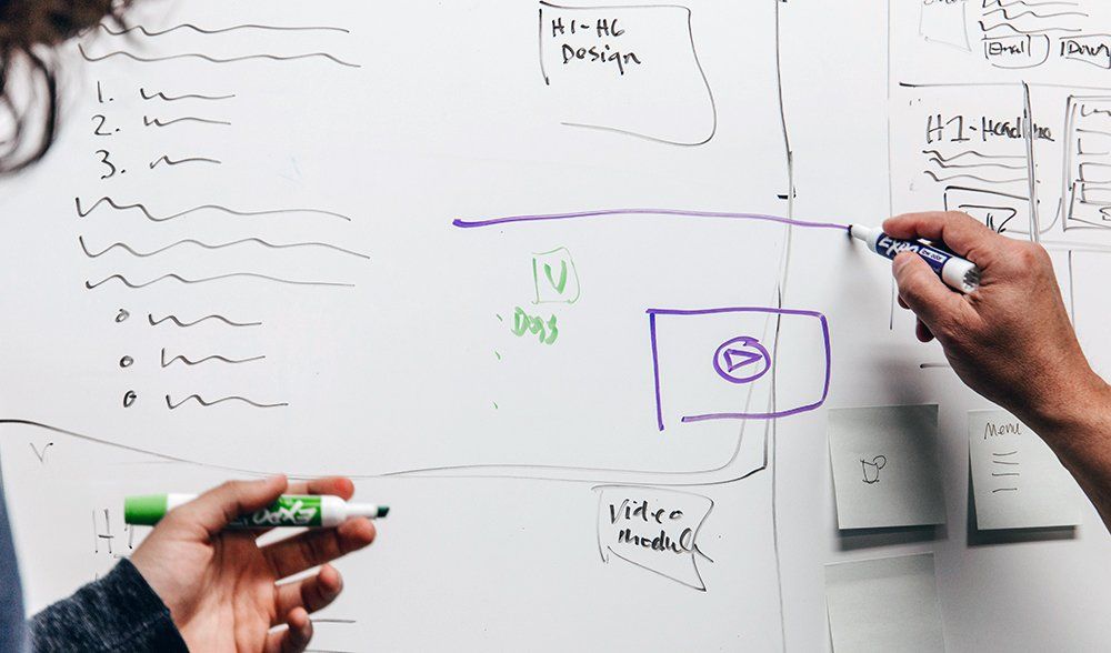 Una persona escribe en una pizarra con un marcador.