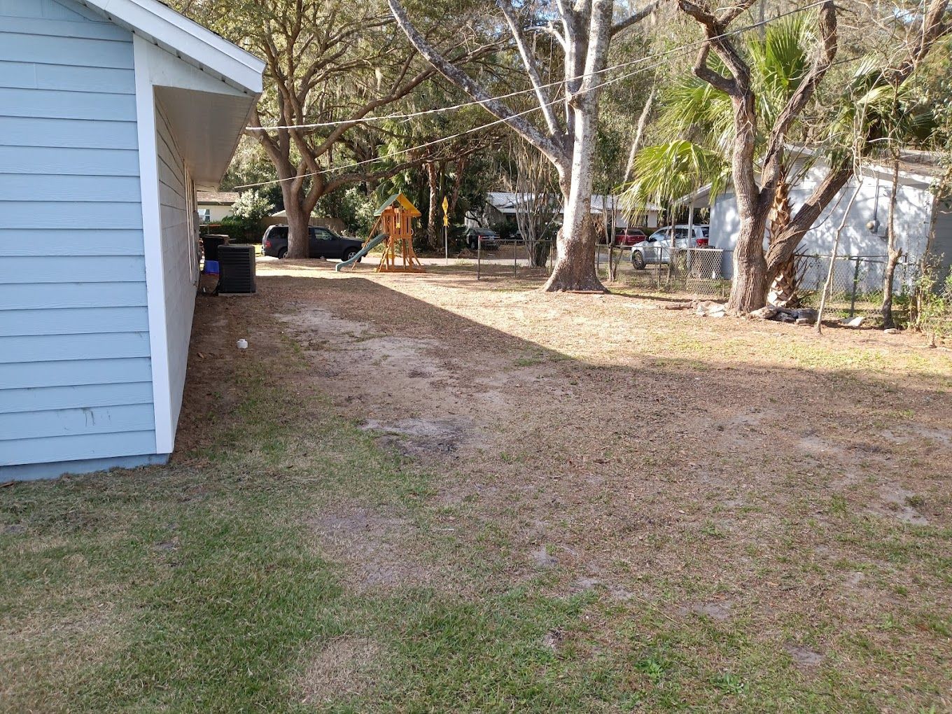 A backyard with a shed and trees in the background.