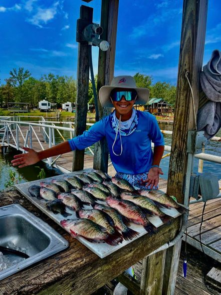 A man is standing in front of a table full of fish.