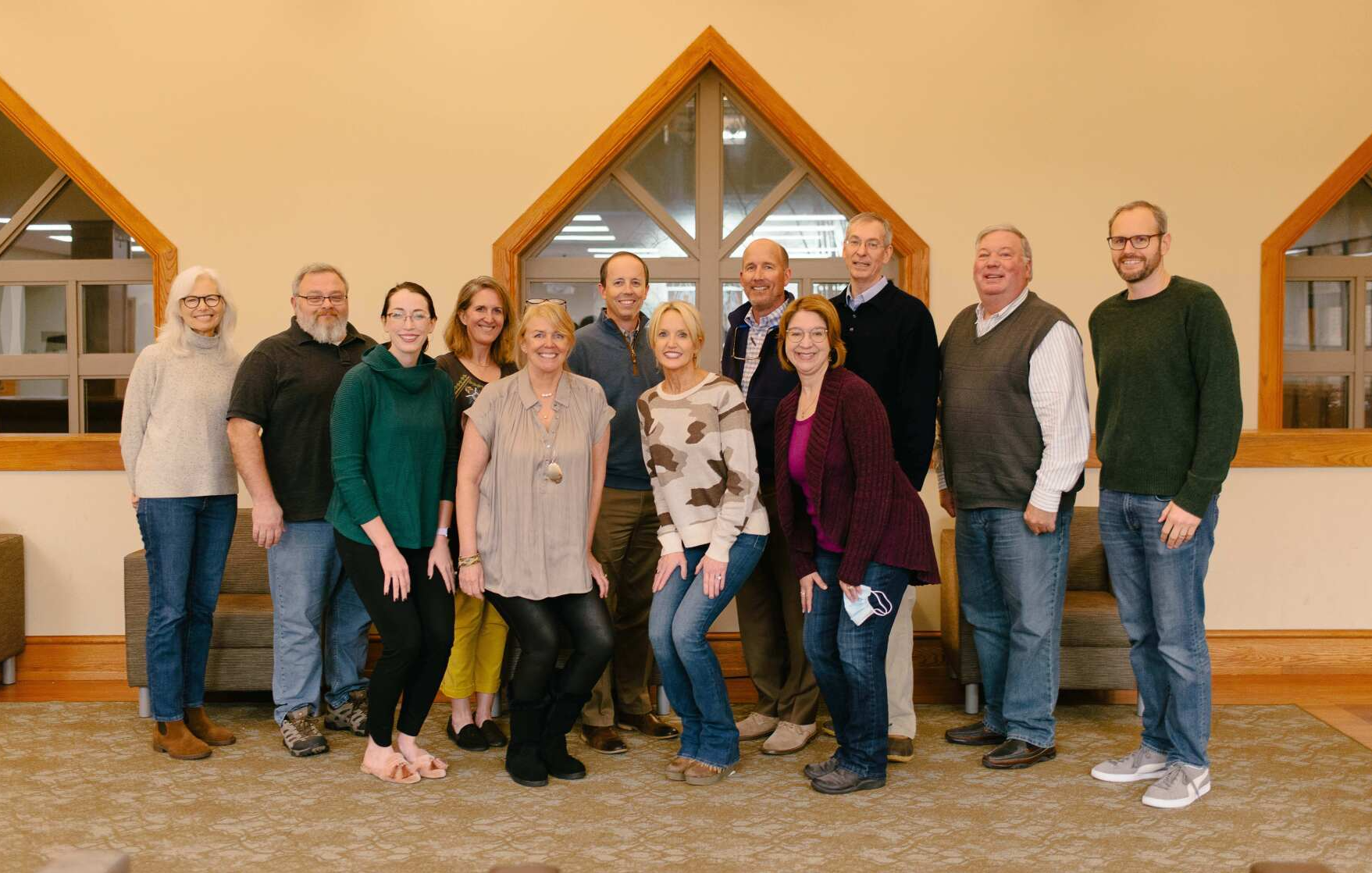 A group of people are posing for a picture in a room.