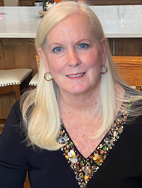 A man in a plaid shirt is smiling in front of a church altar.
