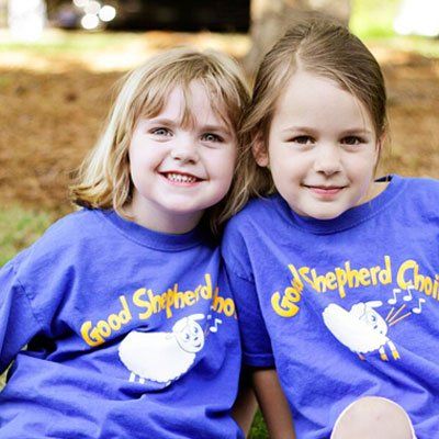 Two little girls wearing blue shirts that say good shepherd