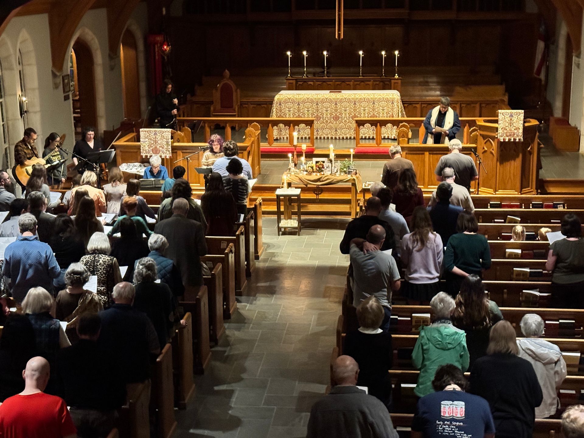 A woman is holding a cross in her hands at sunset.