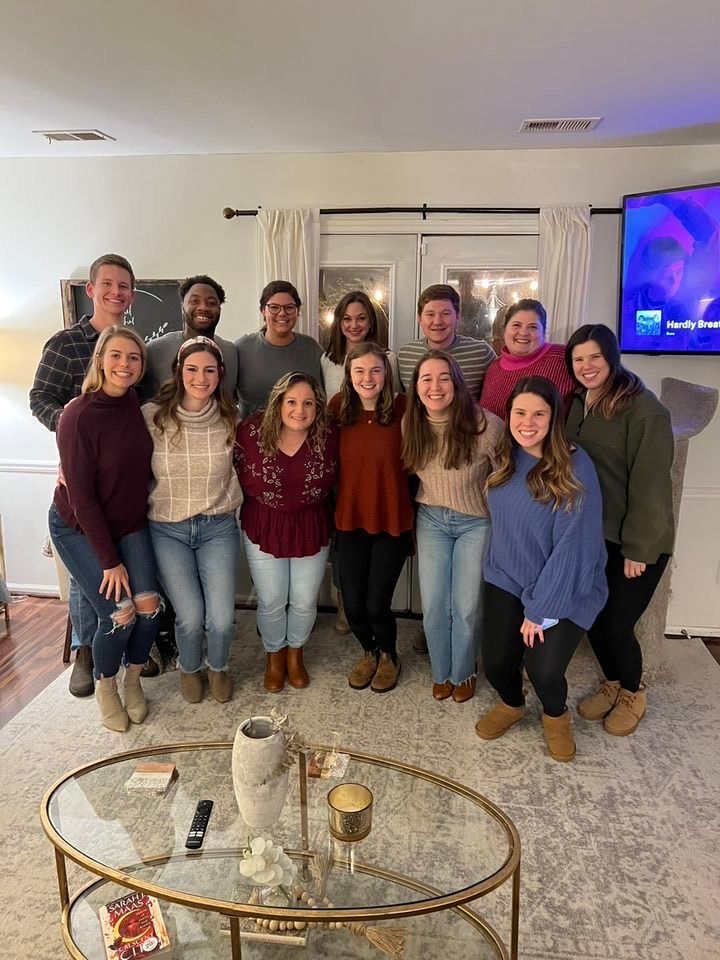 A group of people are posing for a picture in a living room.