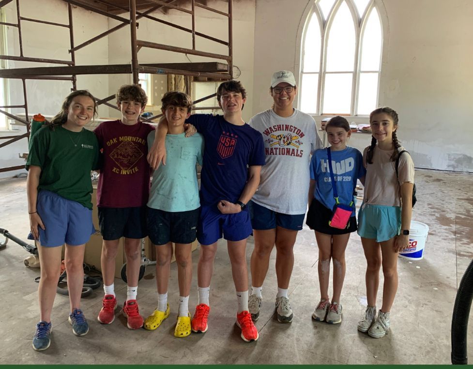 A group of young people are posing for a picture in a room.