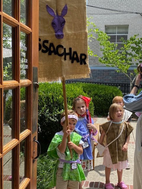 A group of children holding a sign that says sachar