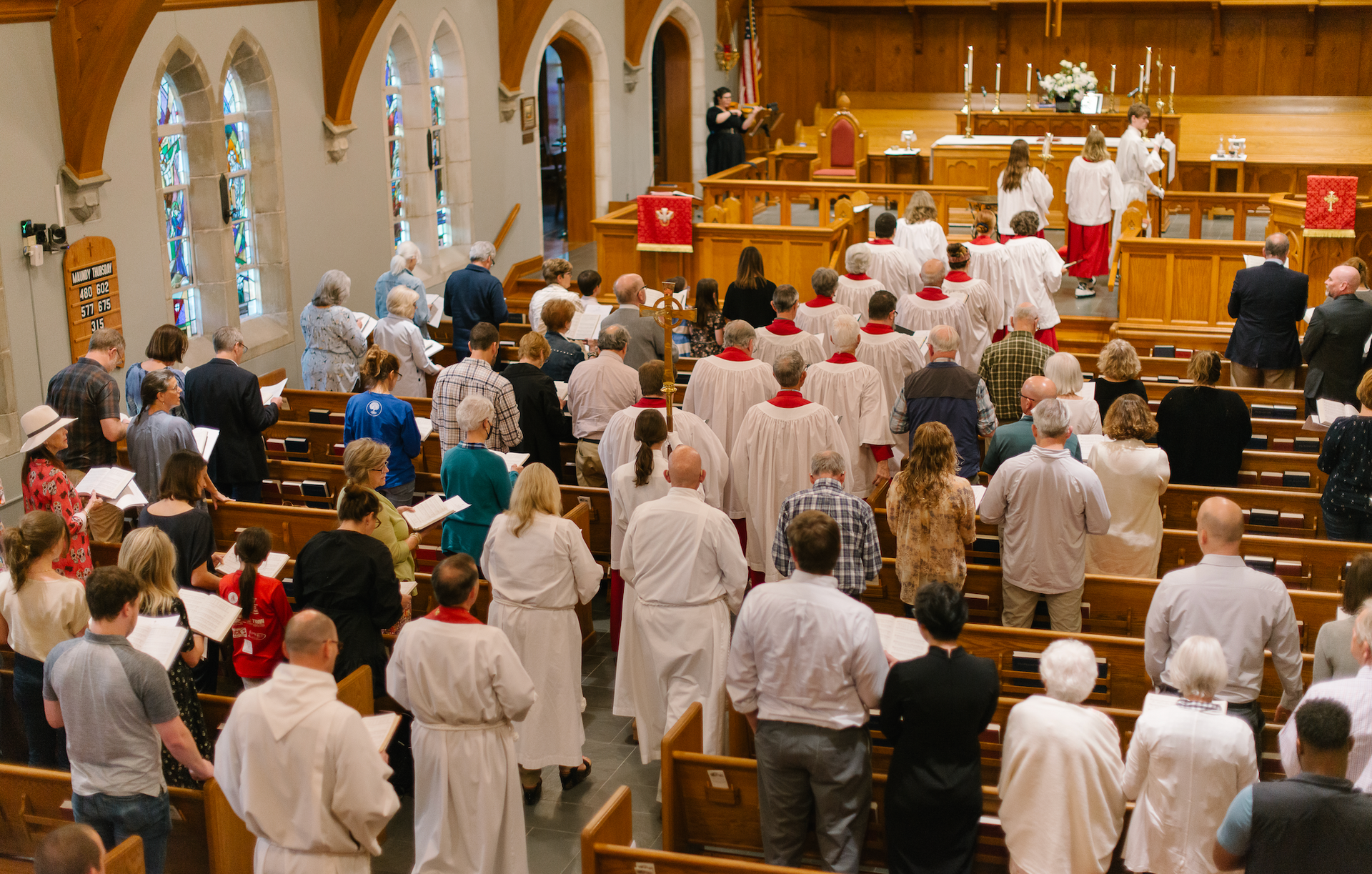 A large group of people are standing in a church.