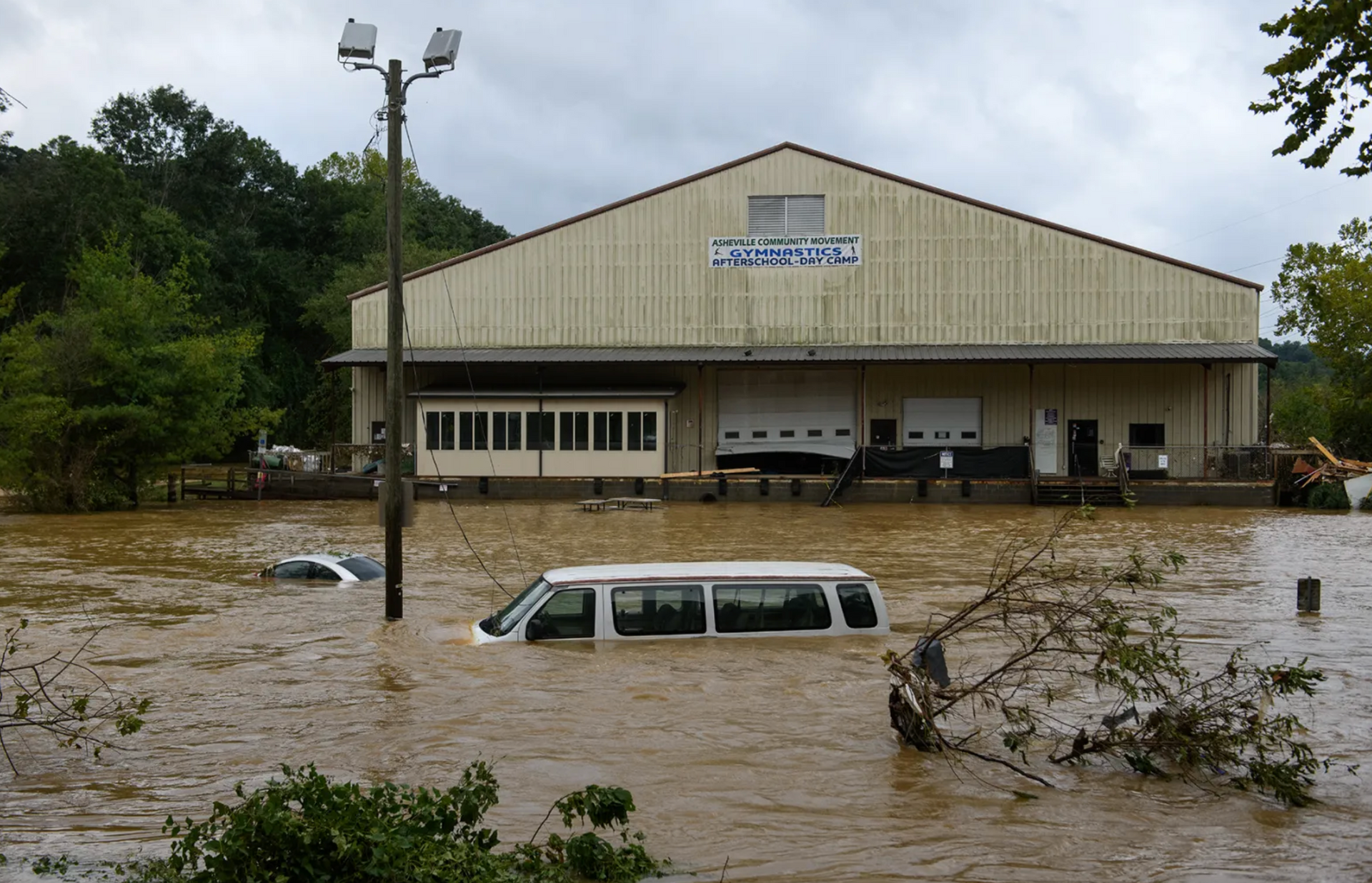 A flooded building with a van in front of it