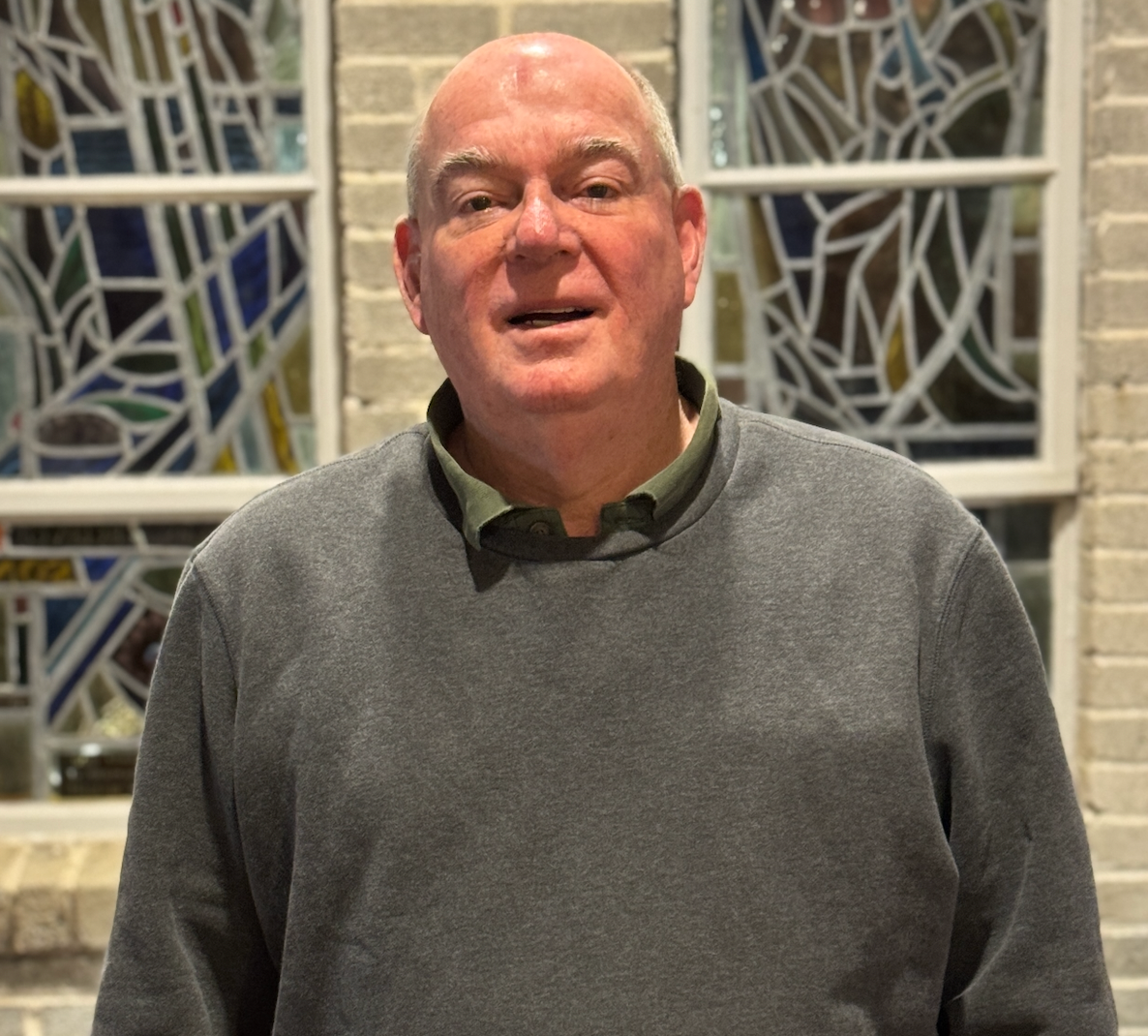 A woman in a black sweater is standing in front of an altar in a church.