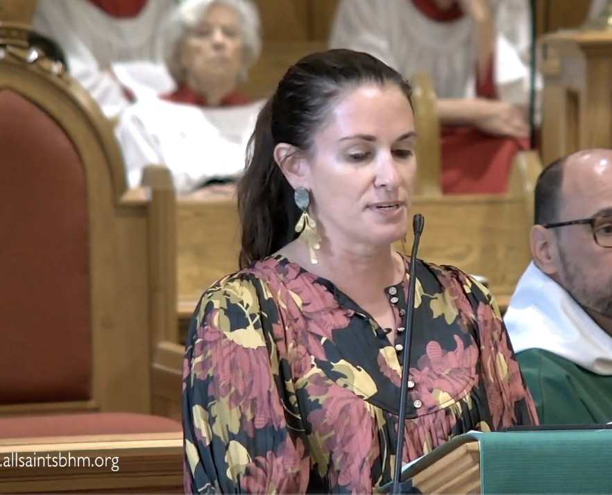 A woman is speaking into a microphone in a church