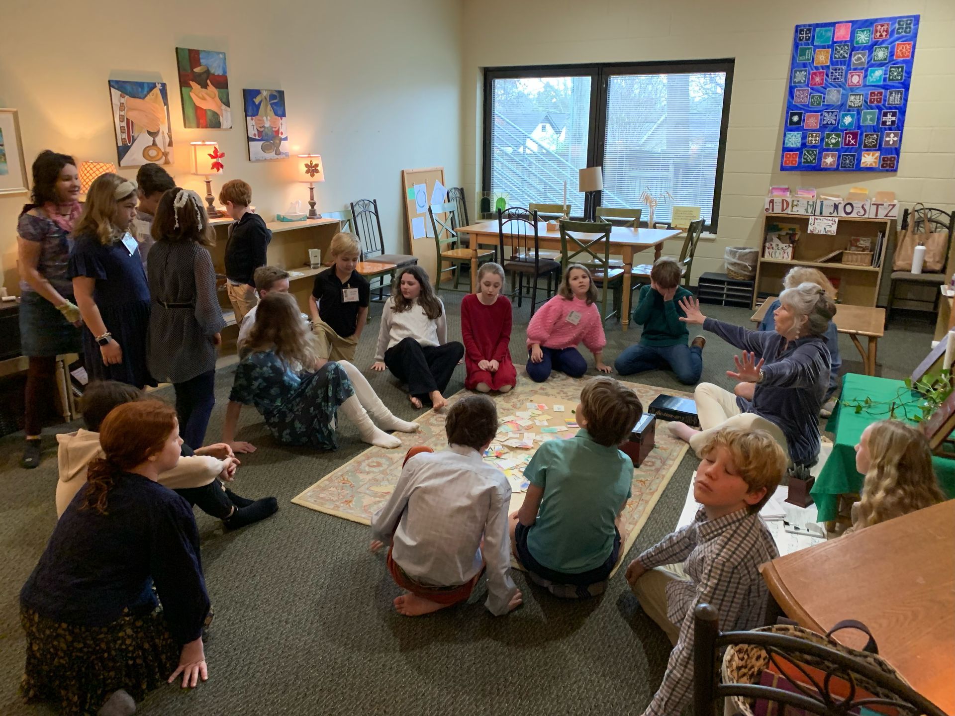 A group of children are sitting in a circle on the floor in a room.