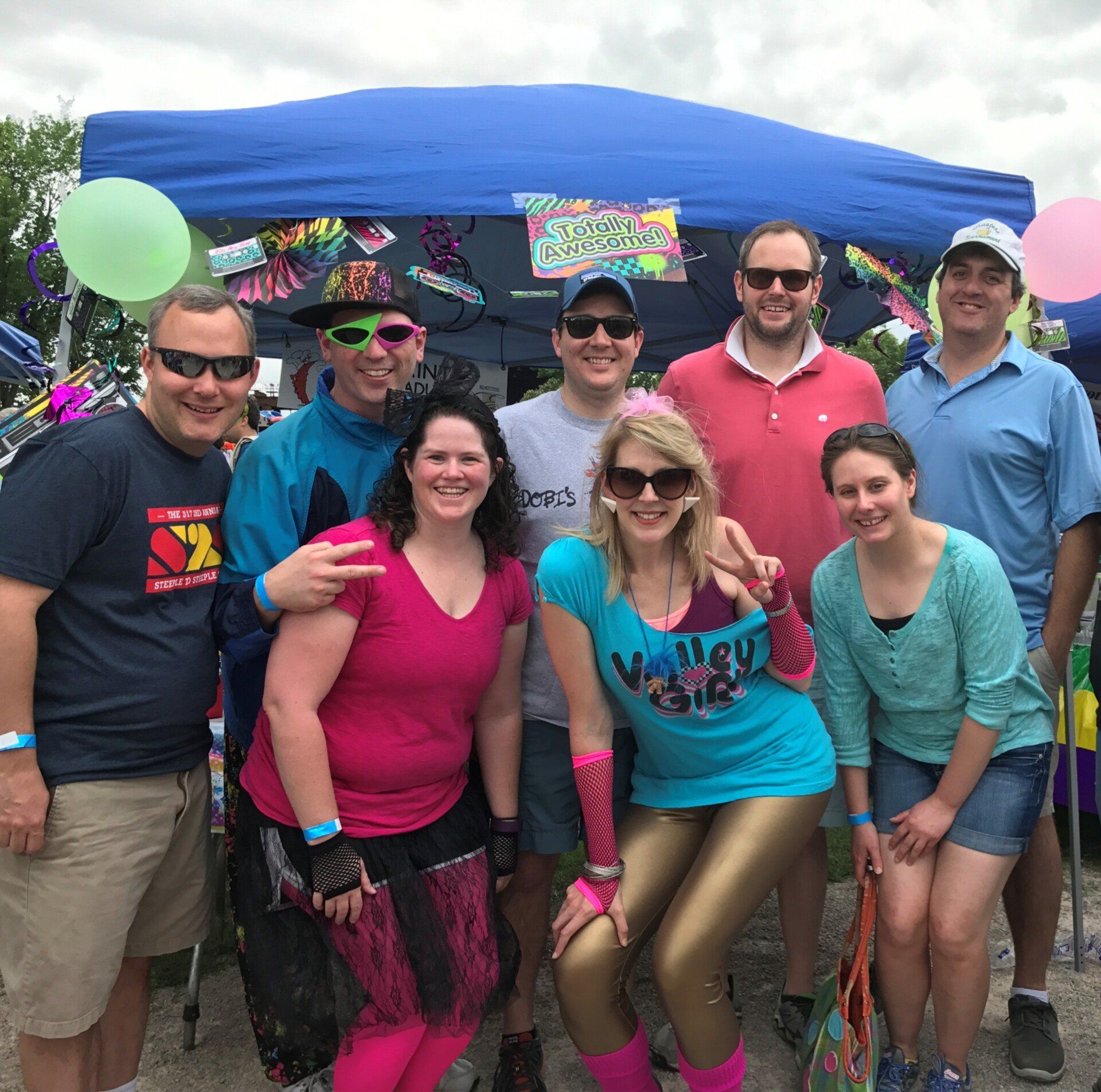 A group of people posing for a picture with one woman wearing a shirt that says valley girl