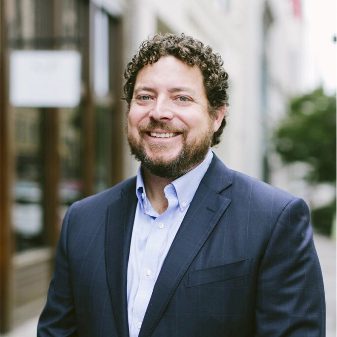 A man in a suit and white shirt is standing in front of a church altar.