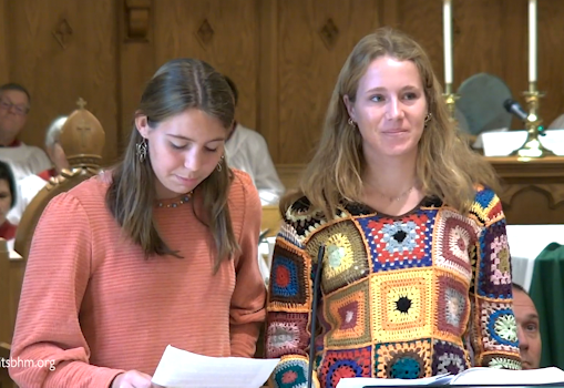 Two women are standing next to each other in a church.