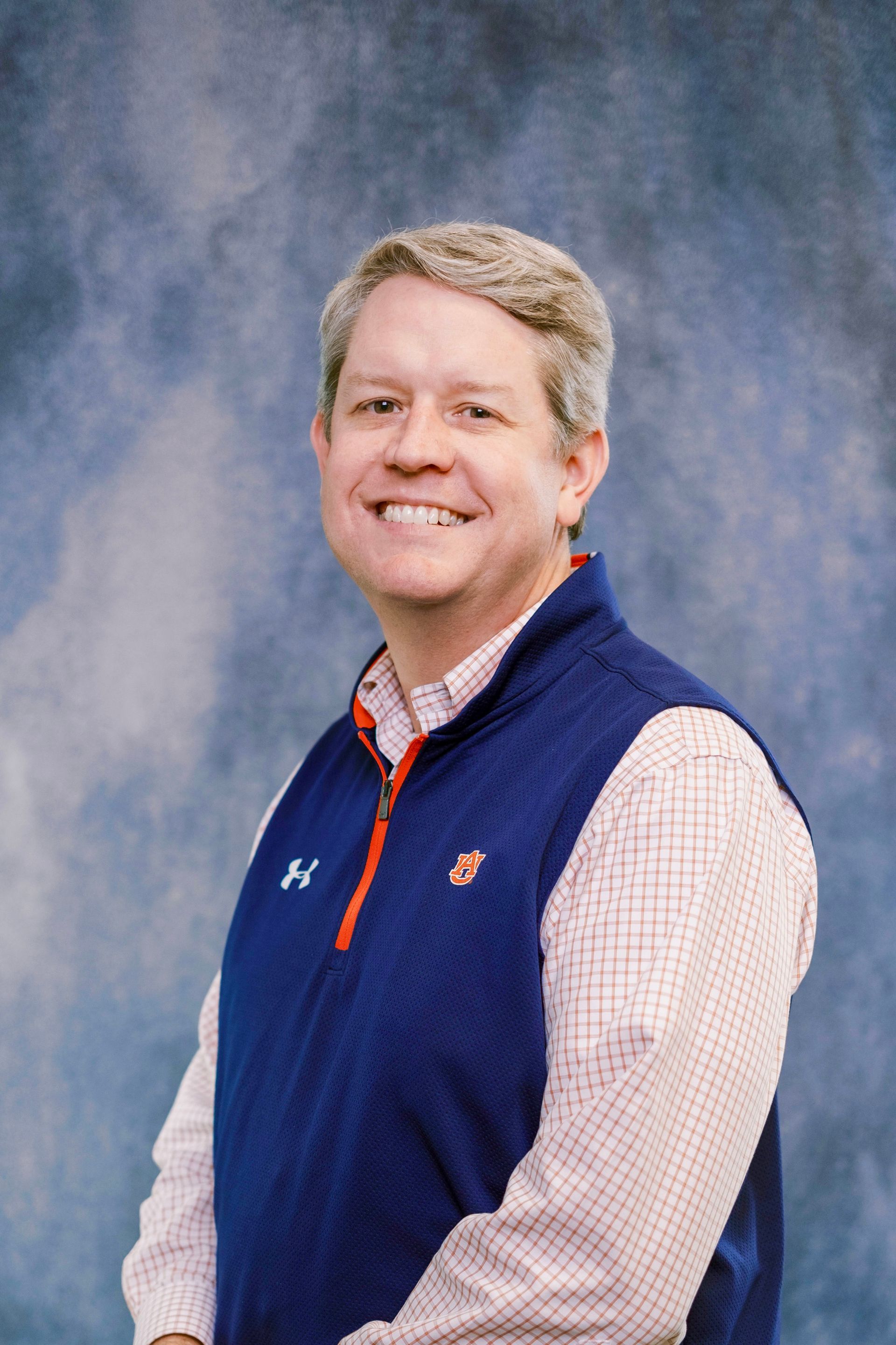 A man in a suit and tie is smiling for the camera.