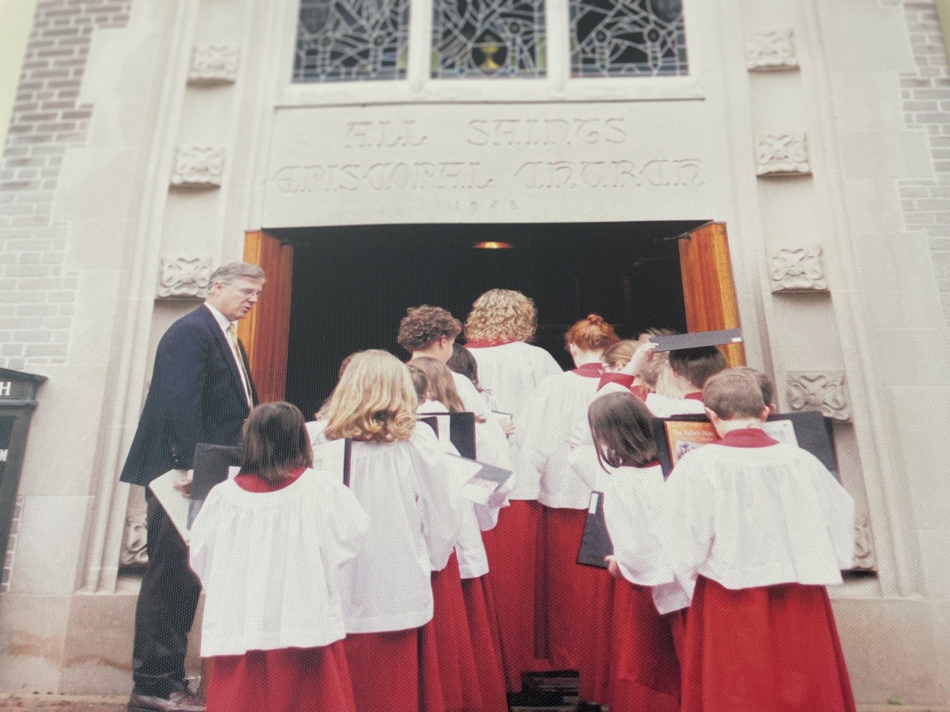 A group of people standing in front of a building that has the word church on it
