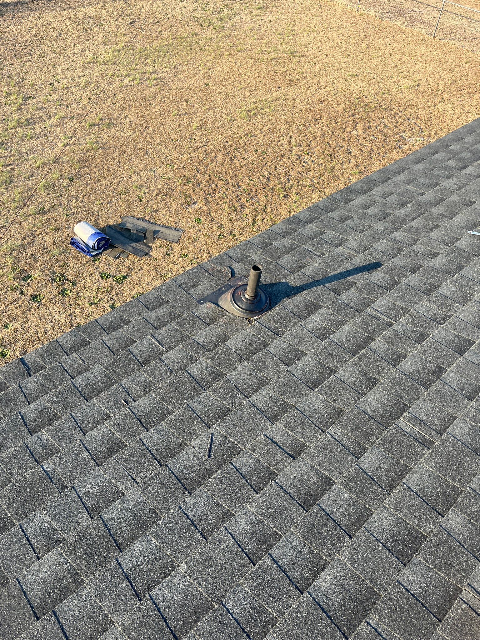 A roof with shingles and a chimney on top of it.