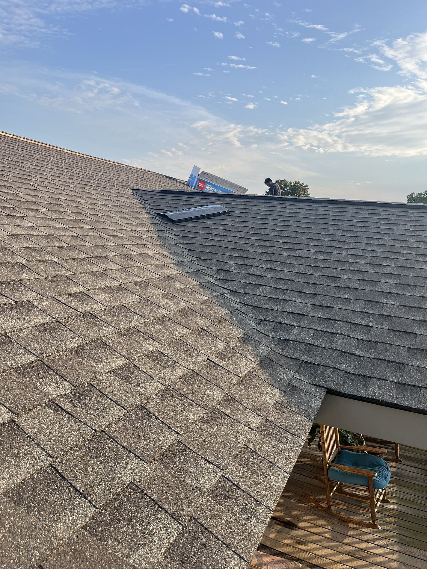 A man is working on the roof of a house.