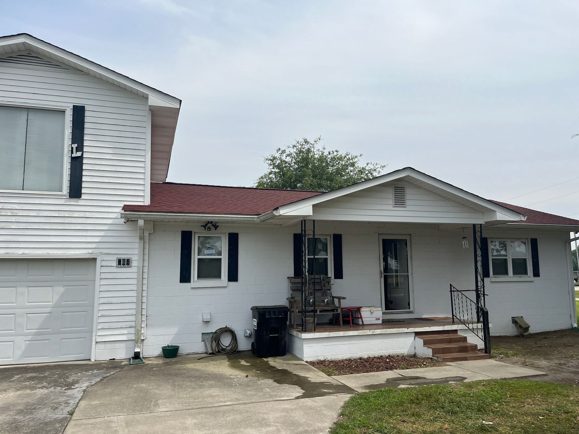 A white house with a red roof and black shutters