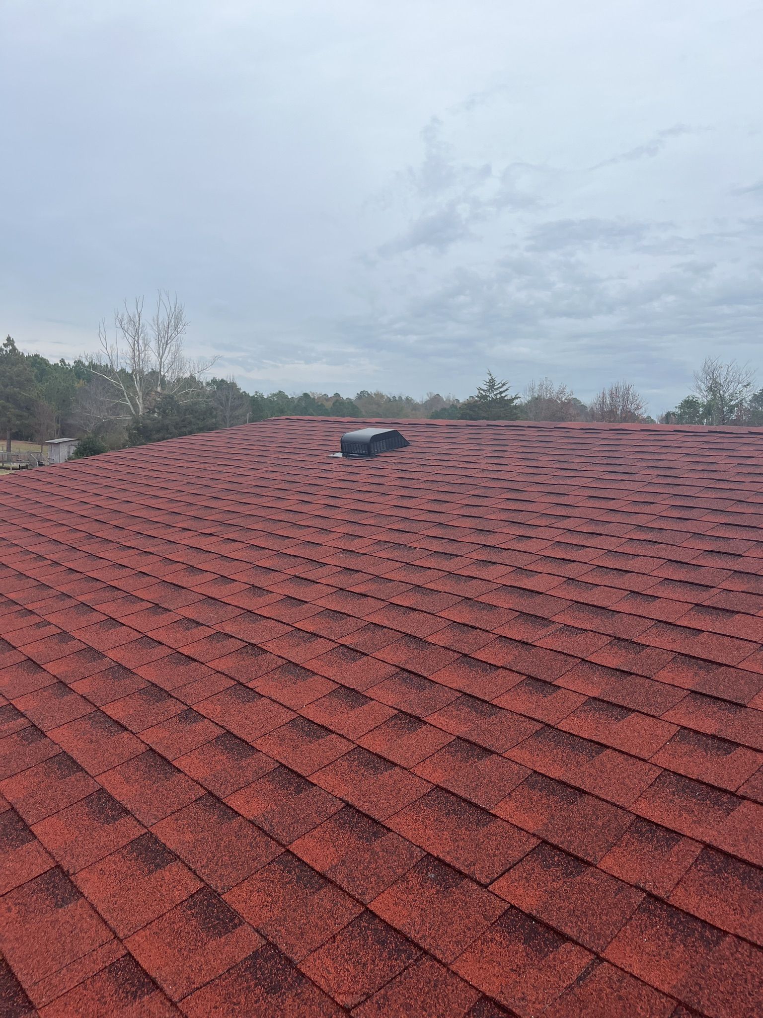 A red roof with a skylight on top of it.