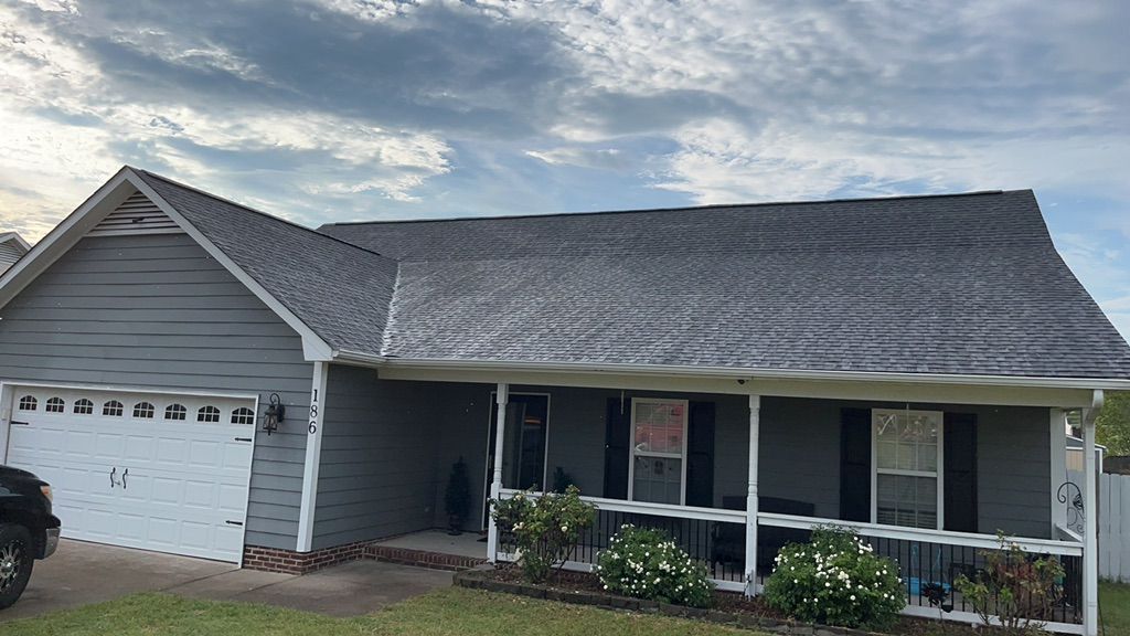 A house with a car parked in front of it and a porch.