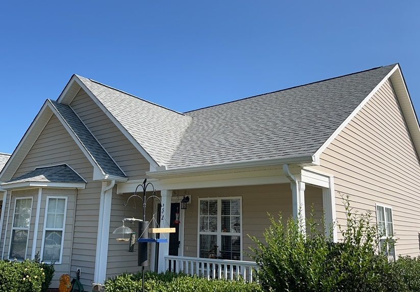 A house with a bird feeder on the porch