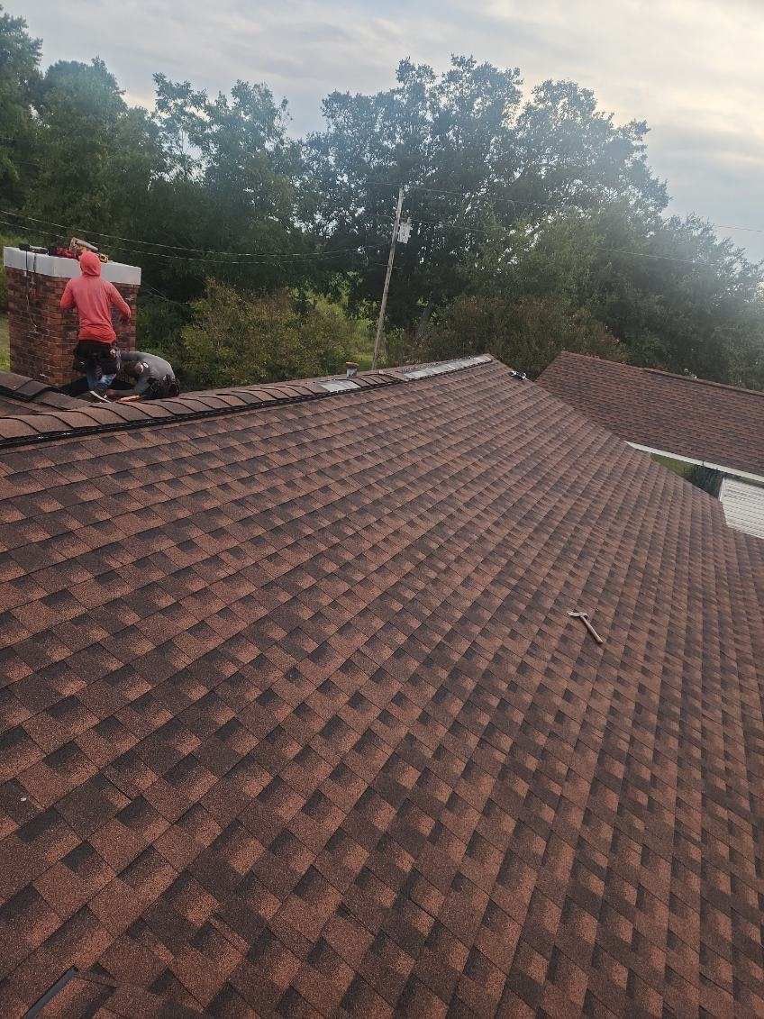 A man is standing on the roof of a house.