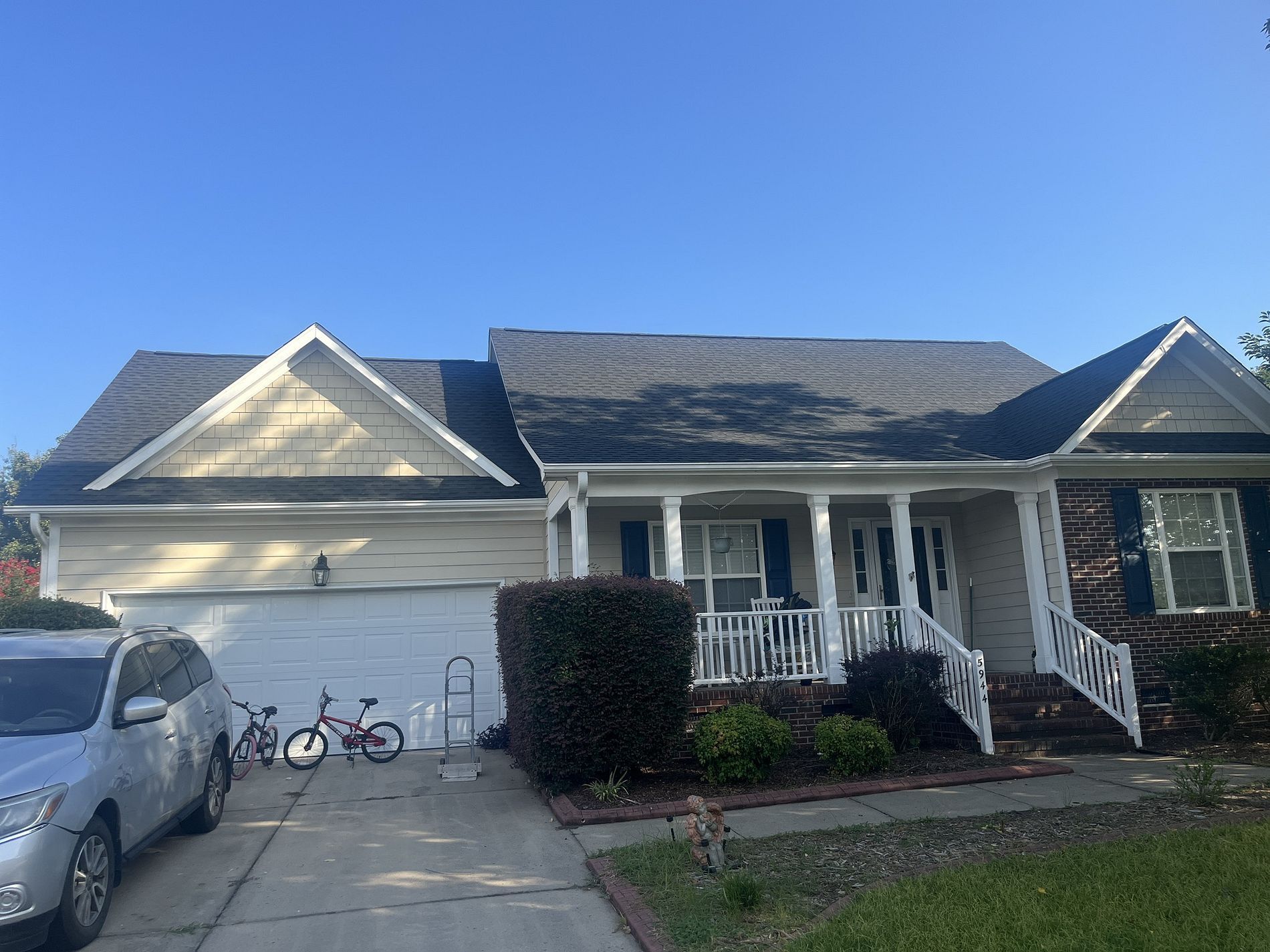 A house with a bird feeder on the porch
