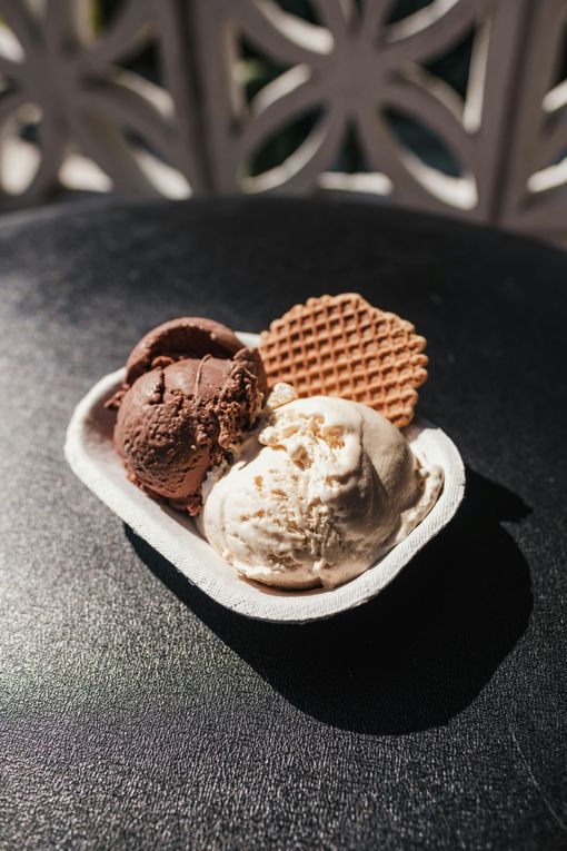 Two scoops of ice cream and a waffle on a table.