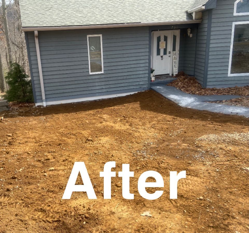 A house with gray siding and a dirt yard after landscaping.