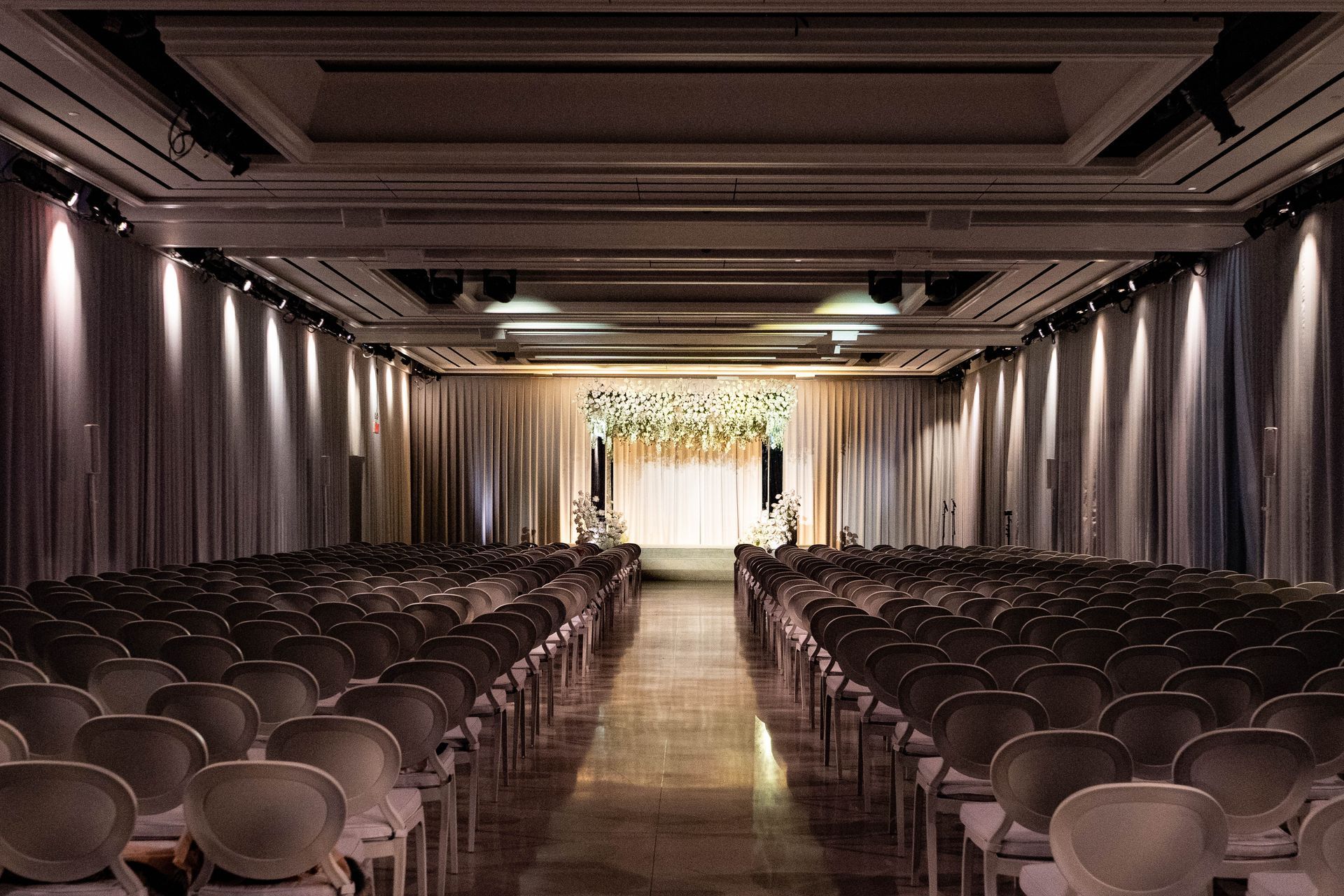 A large room filled with rows of chairs and a stage.