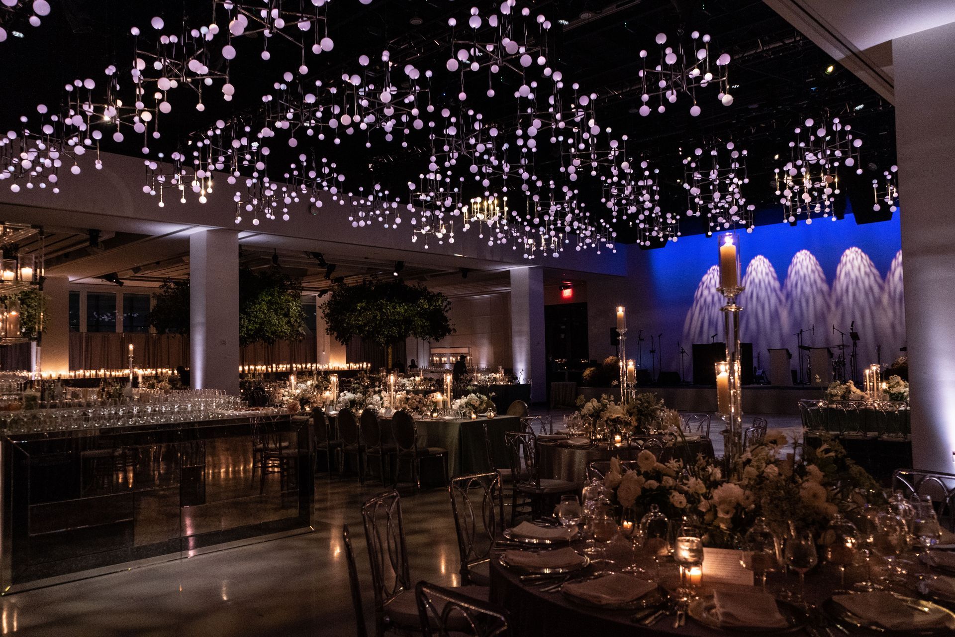A large room with tables and chairs set up for a wedding reception.