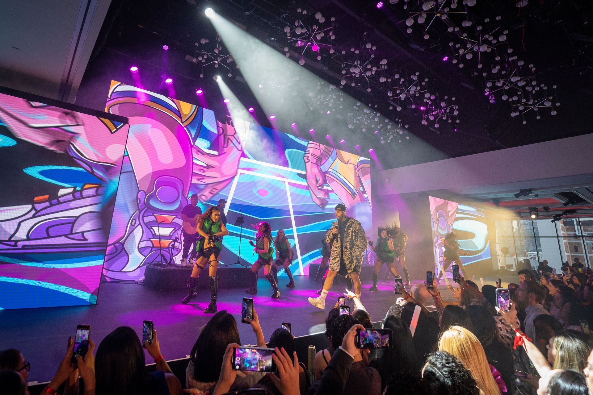 A group of people are standing in front of a stage at a concert.