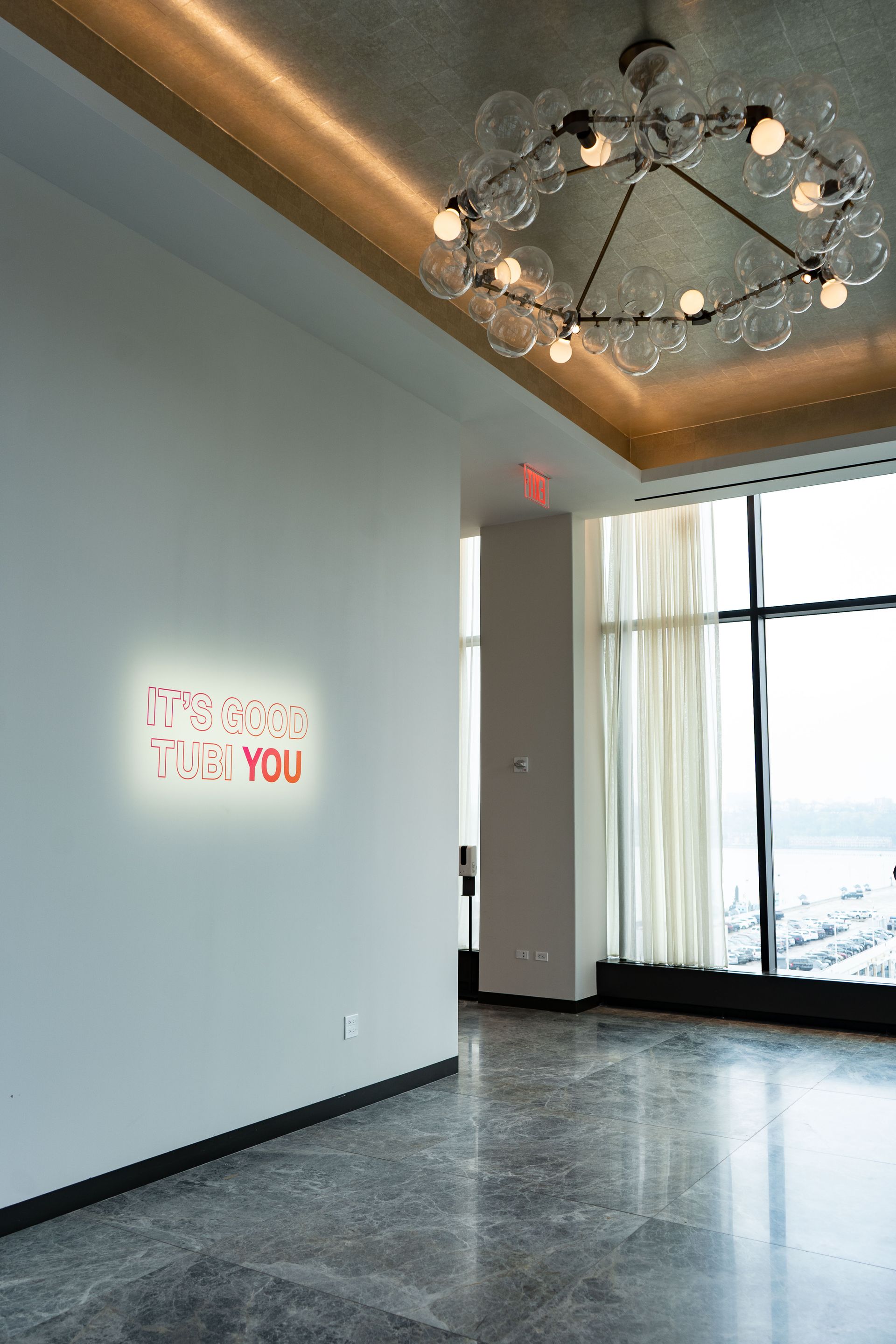 A room with a chandelier hanging from the ceiling and a sign on the wall that says `` i miss you ''.