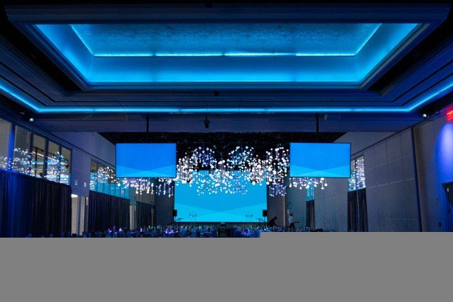 a large room with blue lights and a large screen