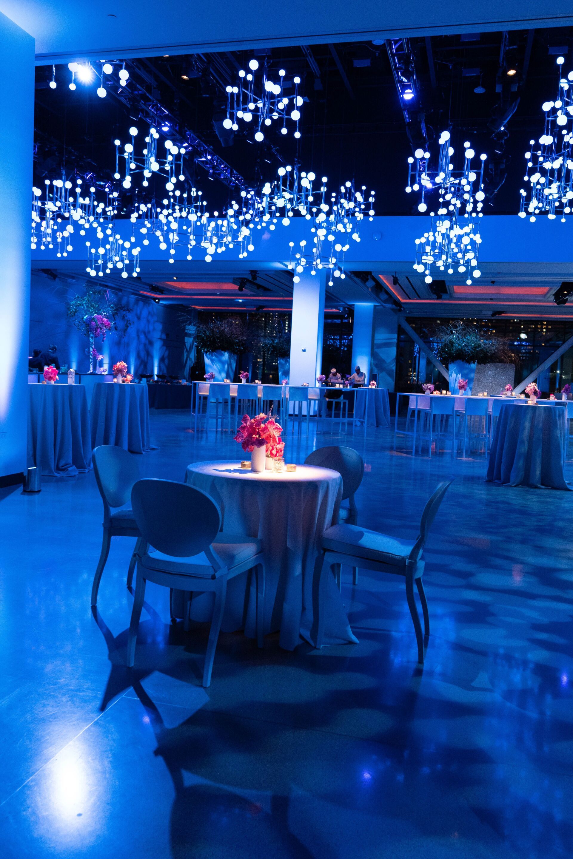 a large room with tables and chairs lit up with blue lights